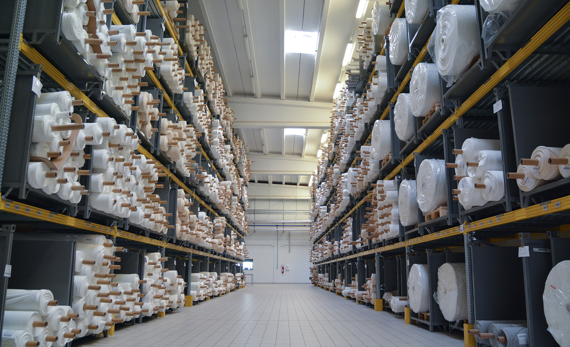 Warehouse aisle stocked with rolled fabric bolts at the ZTTEX factory