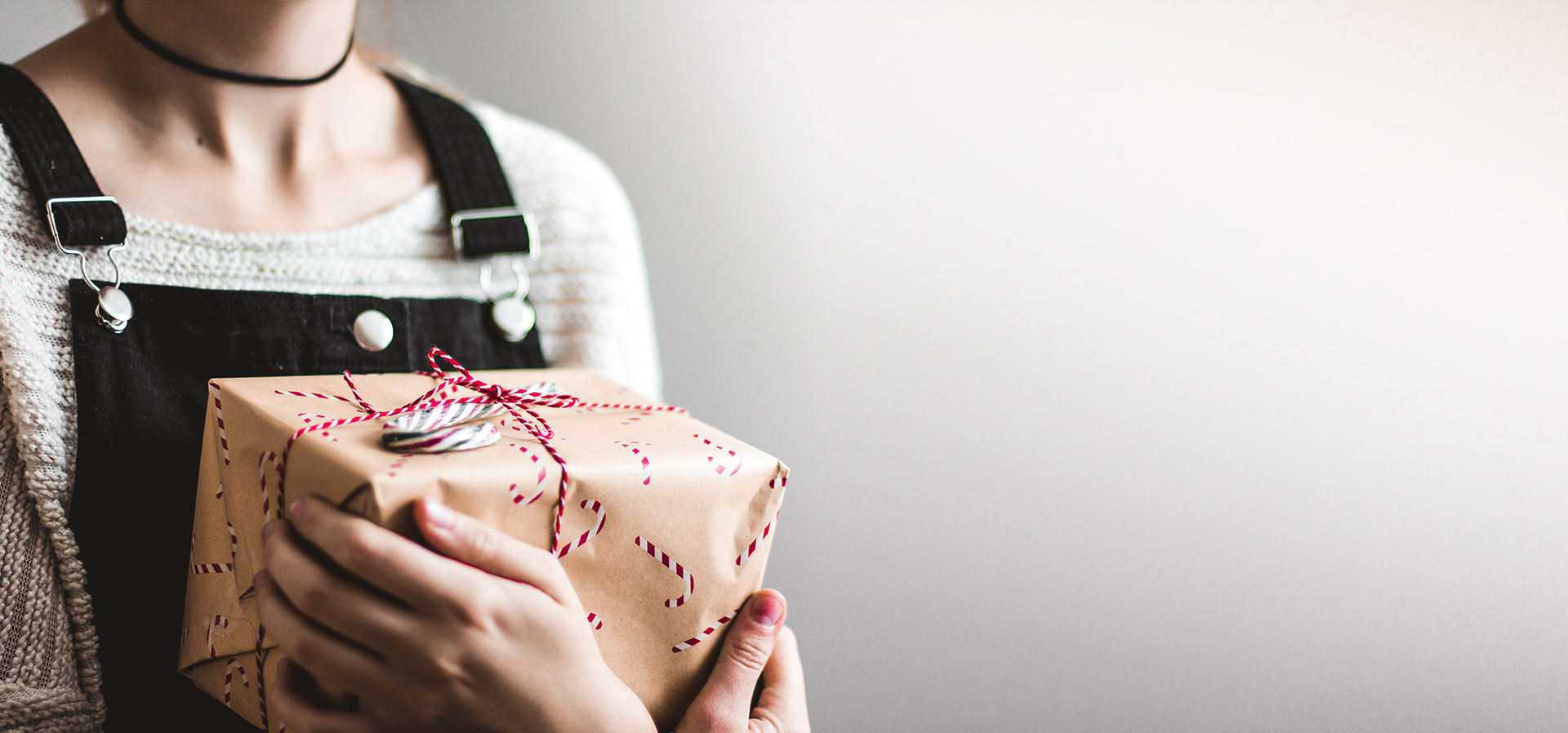 Woman holding a gift-wrapped box tied with string